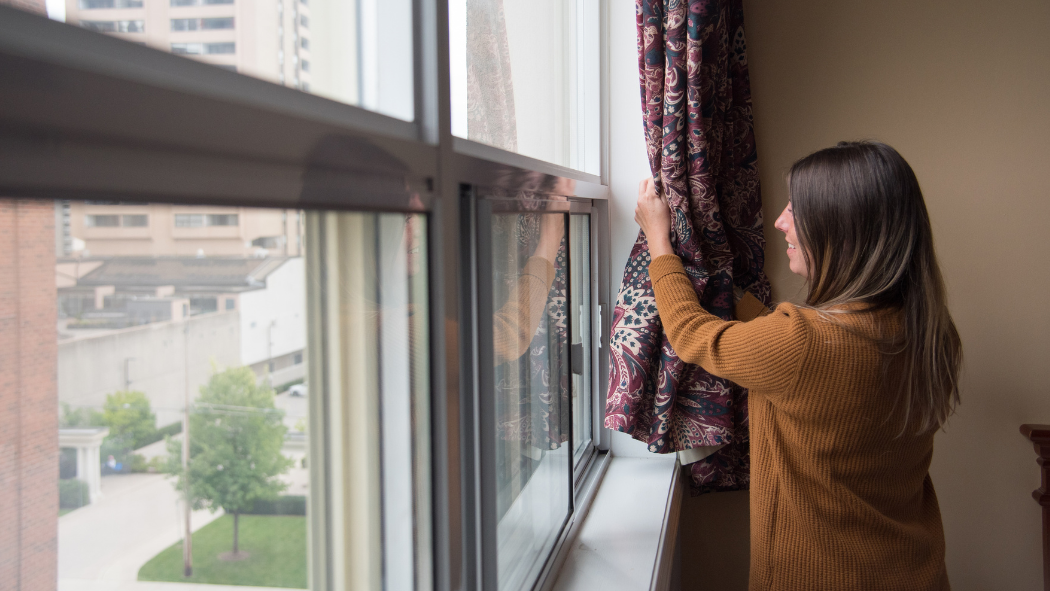 Person opening window curtain