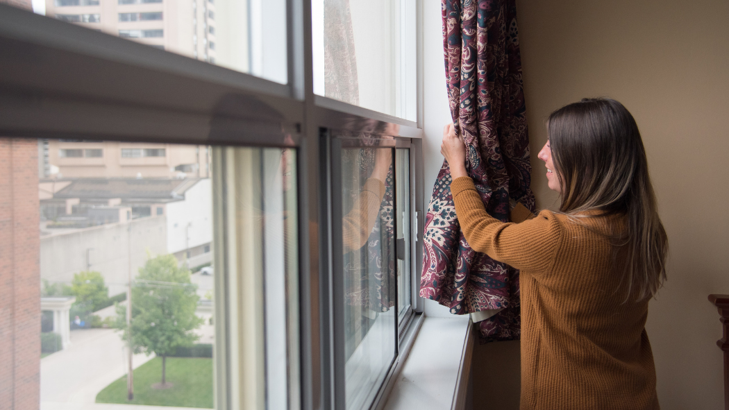 Person opening window curtain 