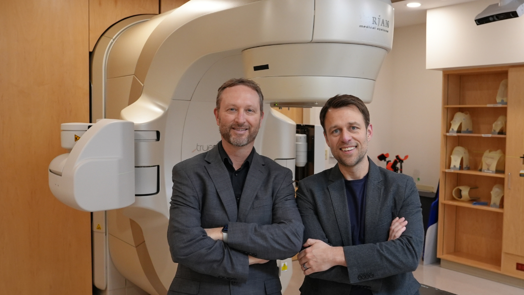 Drs. Gaede and Breadner in front of the linear accelerator