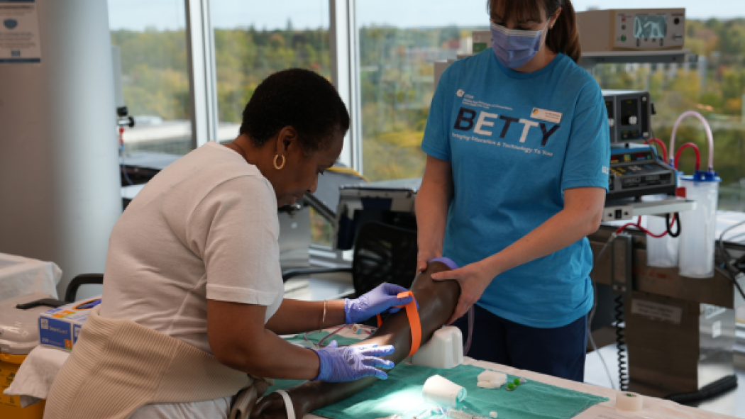 A clinical educator instructs a student on the proper technique for a procedure.