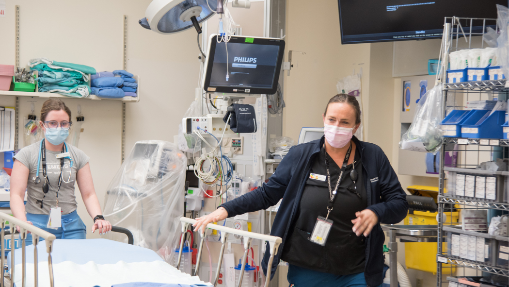 Two Nurses stand over a hospital gurney