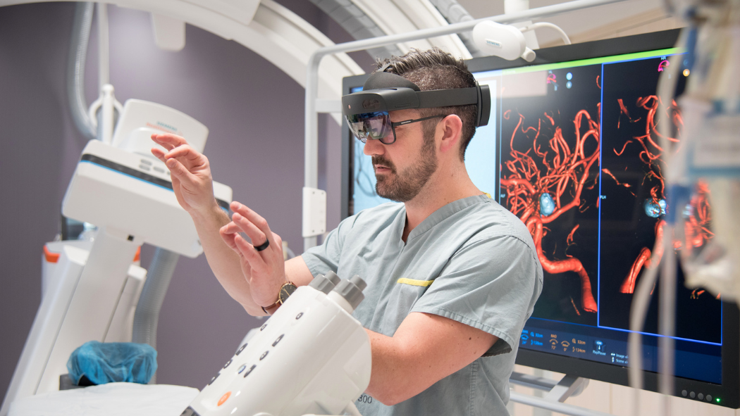 Jonathan Collier, an interventional radiologist at London Health Sciences Centre, demonstrates the use of the HoloLens mixed reality headset in the angiography suite.