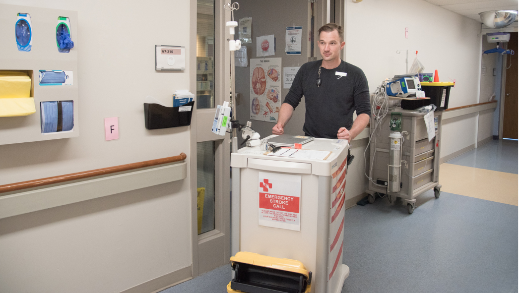 Stroke Unit Nurse pushing stroke cart down hallway of hospital