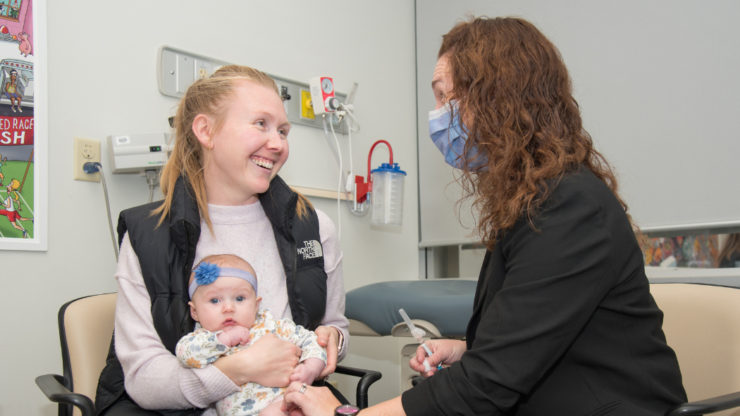 Erin Fleischer (right) preparing to immunize a young patient in the RSV Immunization Clinic.