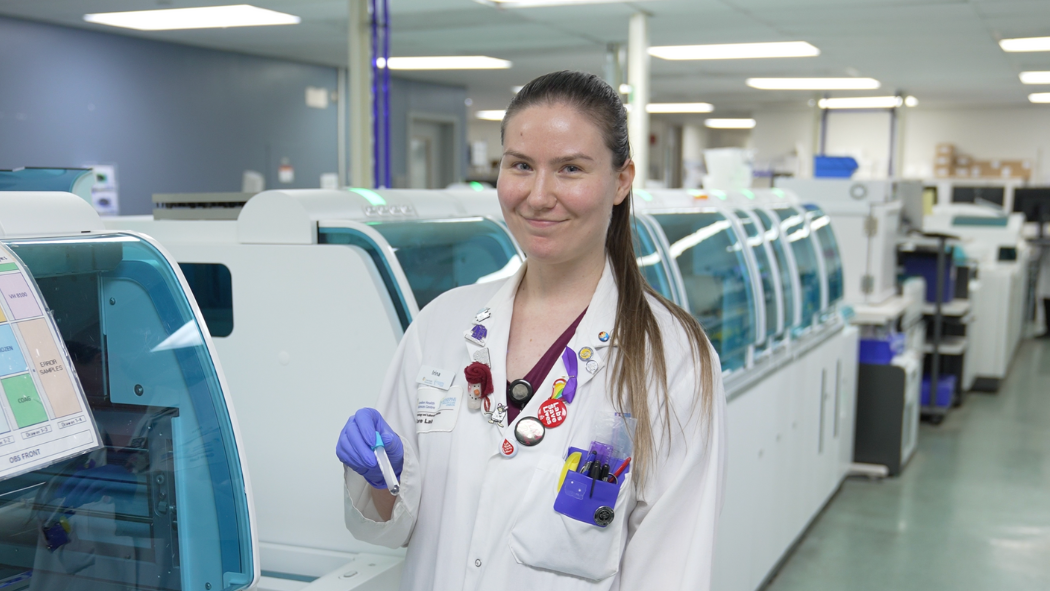 Medical lab technologist standing in lab holding test tube