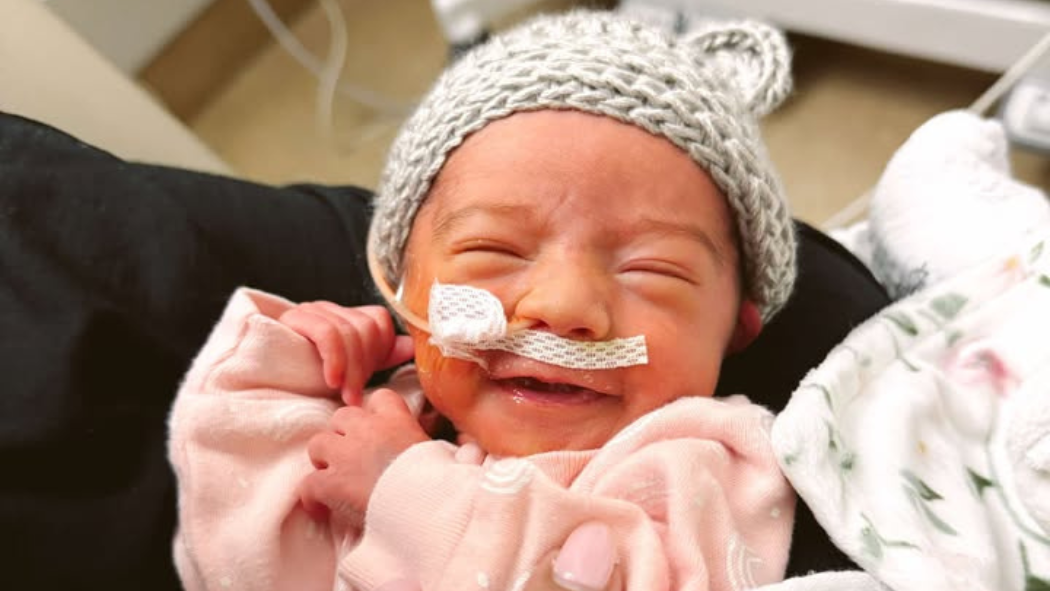 Ivy Spooner's mother, Emily, holds her in the NICU