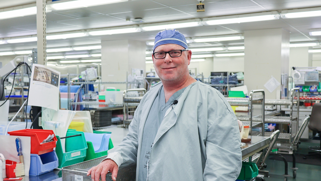 Man standing in medical device reprocessing department smiling at camera