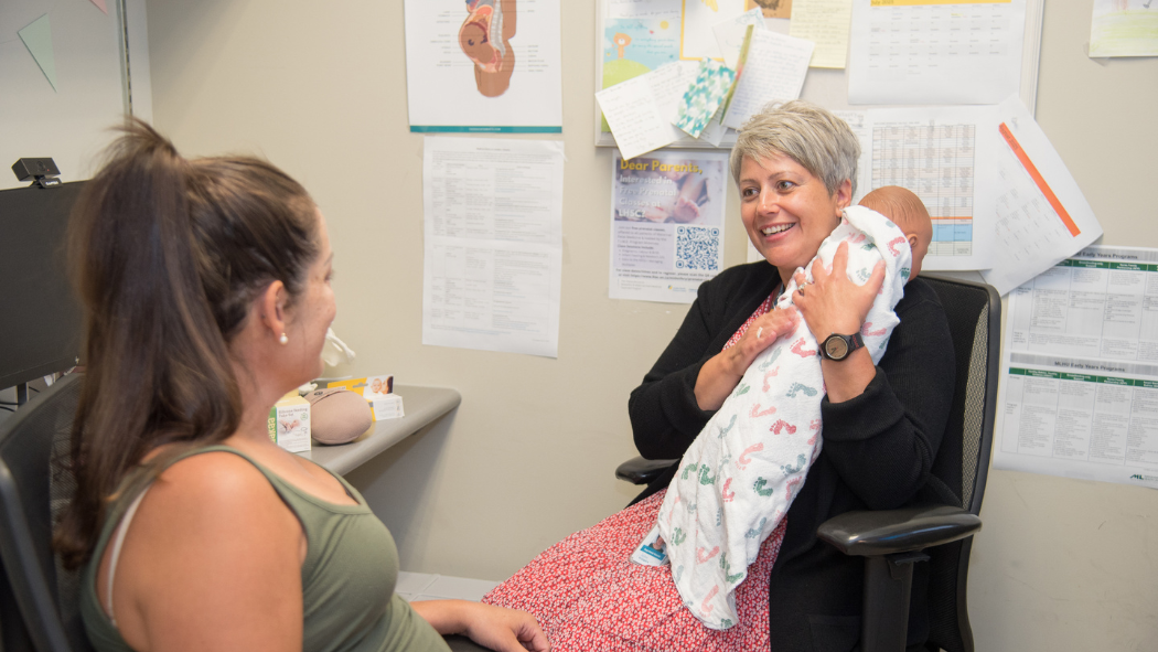 Midwife Jackie Droogers demonstrating infant feeding and burping techniques with a pregnant patient
