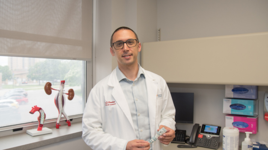 Dr. Landau is pictured with a sample of the aortic stent graft platform