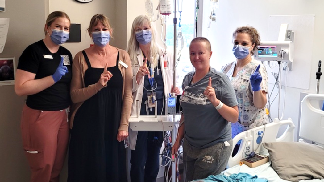 Jaci Van Altena poses for a photo in her hospital room with four members of her care team. 
