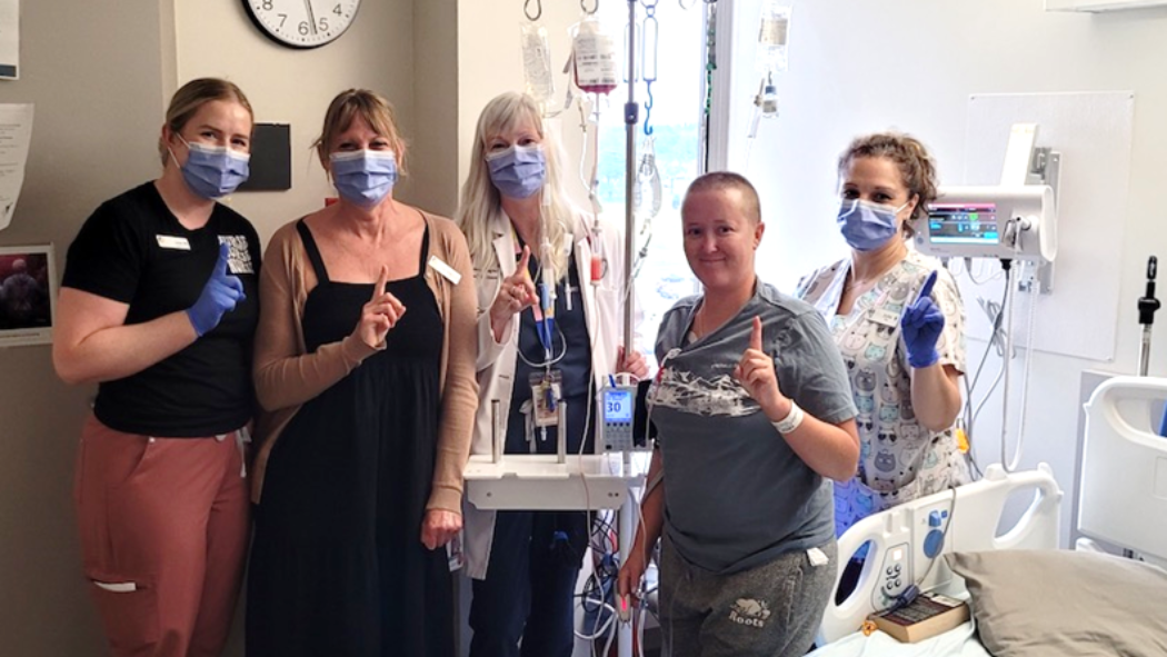 Photo of Jaci VanAltena, (patient, unmasked) with her care team in the Blood and Marrow Transplant Program (BMTP). From left: Sarah Mitchell, Registered Nurse; Lisa Bugaliski, Manager; Adrienne Fulford, Nurse Practitioner; Jaci VanAltena; and Julie Adam, Registered Nurse. 