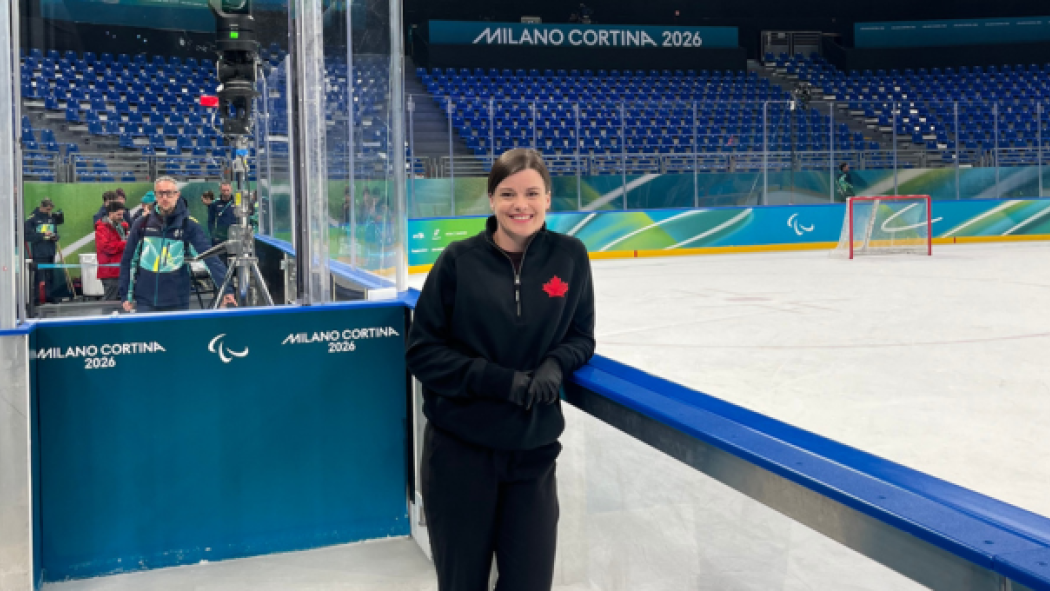 Dr. Danielle Kelton poses next to the Milano-Cortina Paralympic ice rink. 