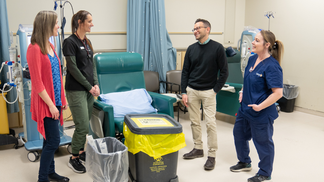 Photo from left: Melissa Costella (Manager, Renal Program), Laura Tait (Charge Nurse, Westmount Dialysis Unit), John Vecchio (Environmental Waste Specialist, Facilities Planning & Design), and Kayla Delaney, Housekeeper (Compass One) discussing the new hemodialysis waste process. 