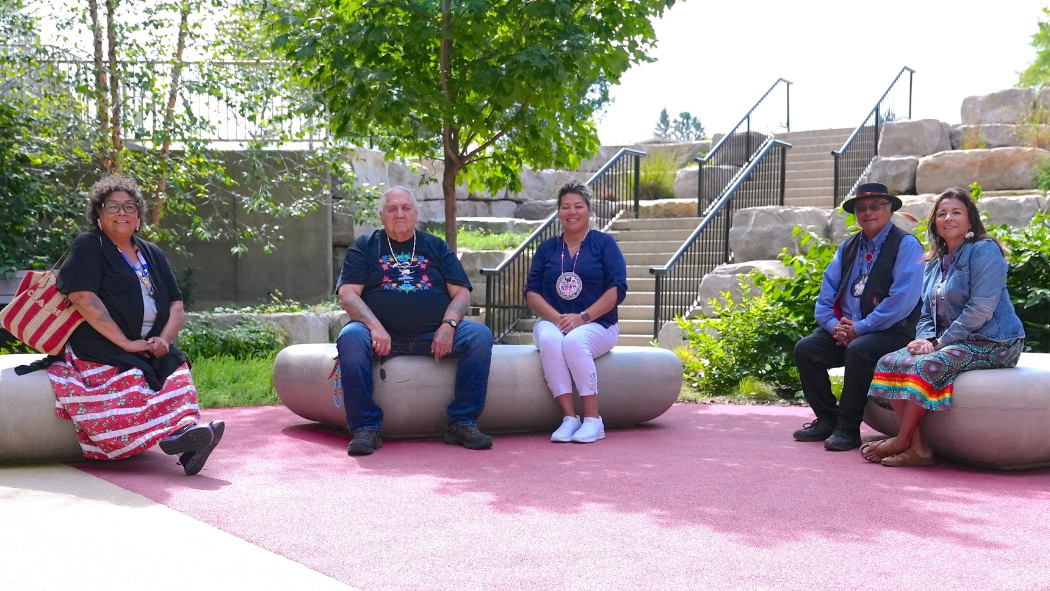 A group of individuals sitting on large rocks in a garden